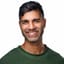 Khurram Naik smiling in a green sweater
